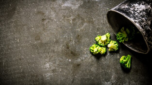 Resh groene broccoli in de oude pot. Op een stenen achtergrond.