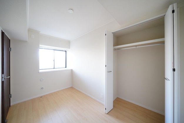 Residence room with storage space, white wall and wood floor