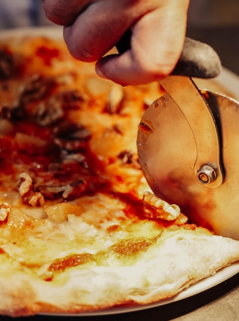 Foto lo chef residente sta facendo un ottimo lavoro con il tagliapizza creando fette deliziose per tutti