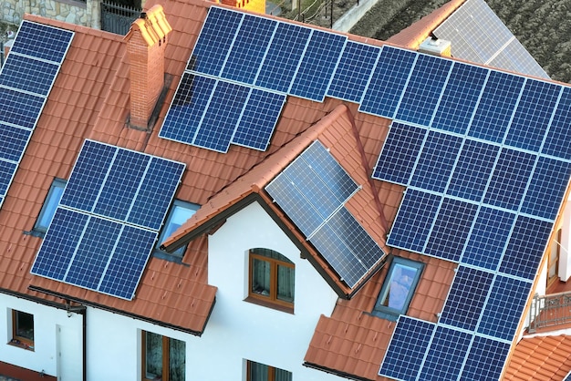 Photo residential house with rooftop covered with solar photovoltaic panels for producing of clean ecological electrical energy in suburban rural area concept of autonomous home