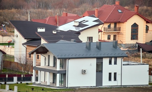 Residentiële huizen met daken bedekt met metalen en keramische dakspanen in landelijke buitenwijk.