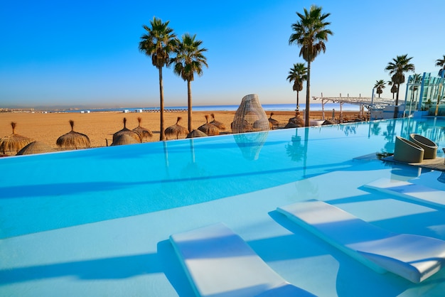 Resort infinity pool in a beach with palm trees