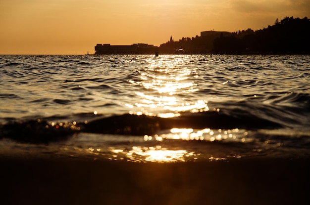 resort town in Slovenian coast. orange sunset sky in summer. Scenic view to wooden pier. Sea