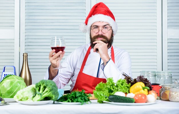 Responsibility cooking christmas dinner. Healthy christmas holiday recipes. How make your christmas dinner healthier. Man bearded chef wear santa claus hat cooking. How to enjoy holiday meals.