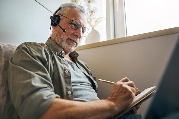 Photo responsible aged man working remotely from home