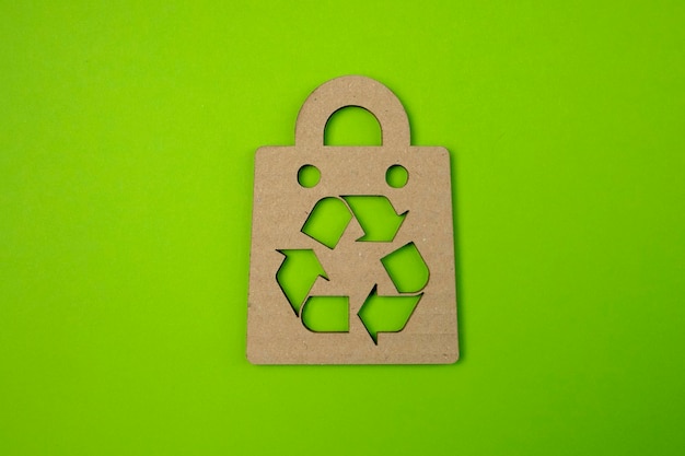 Foto consumo responsabile le frecce riciclano il simbolo e la borsa della spesa in stile taglio carta ecofriendly business banner orizzontale con texture di carta ecologica riciclata copia spazio per il testo