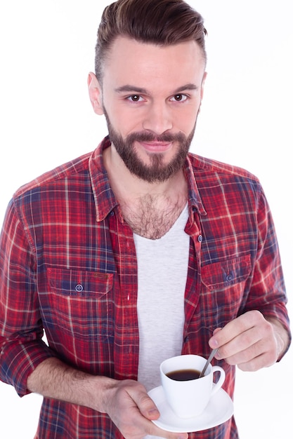 Rest and coffee break Bearded handsome young man in checkered shirt holding coffee or tea cup and smiling while standing against white background