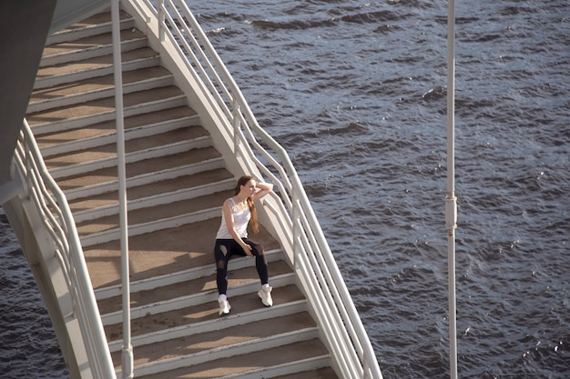 Rest of a young sportswoman on the steps