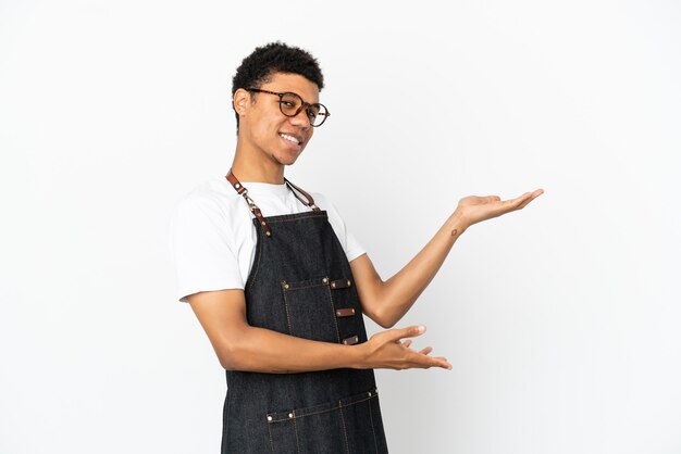 Restaurant African American waiter man isolated on white background extending hands to the side for inviting to come