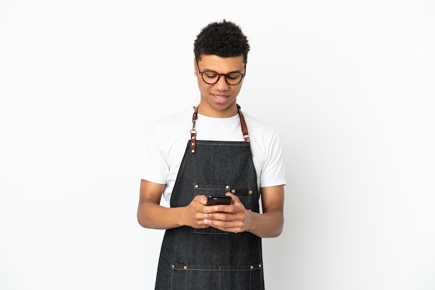 Restaurant Afro-Amerikaanse ober man geïsoleerd op een witte achtergrond die een bericht verzendt met de mobiel