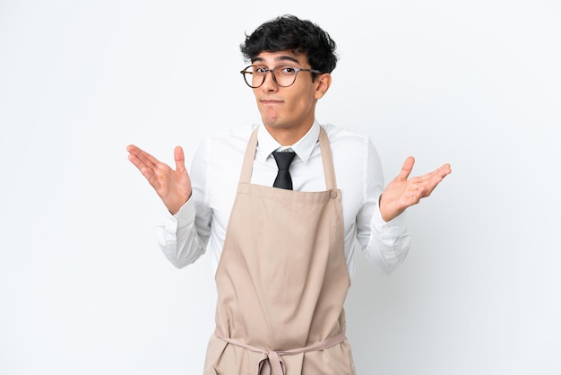 Restaurant Argentinian waiter isolated on white background having doubts while raising hands