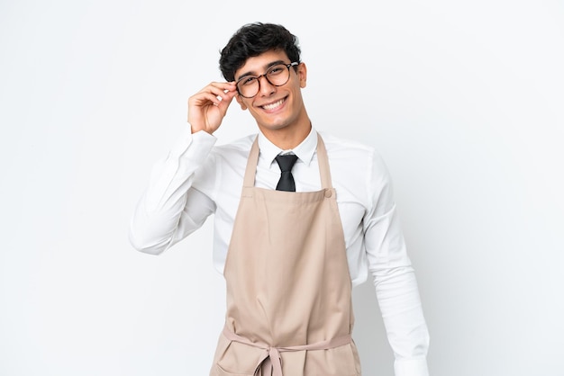 Аргентинский официант ресторана изолирован на белом фоне в очках и счастлив