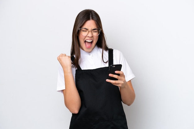 Restaurant Braziliaanse ober vrouw geïsoleerd op een witte achtergrond met telefoon in overwinningspositie