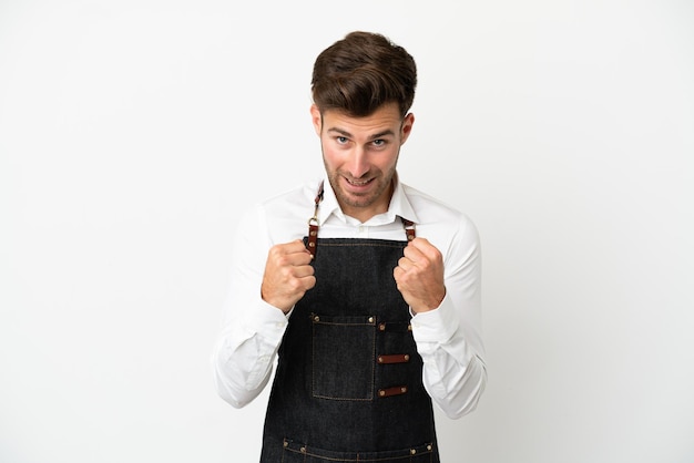 Restaurant caucasian waiter isolated on white background celebrating a victory in winner position