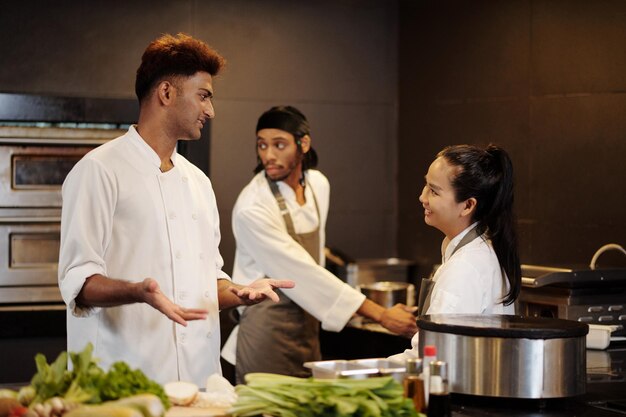 Restaurant chef showing kitchen to new worker on her first day