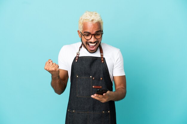 Restaurant Colombian waiter man isolated on blue background surprised and sending a message