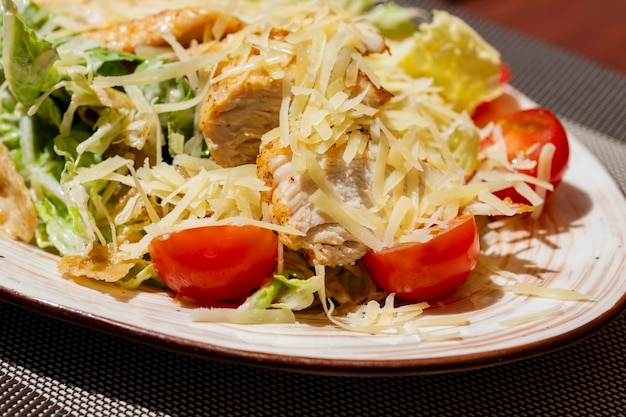 Restaurant food salad with roasted chicken fillet lettuce mix cherry tomatoes and parmesan closeup