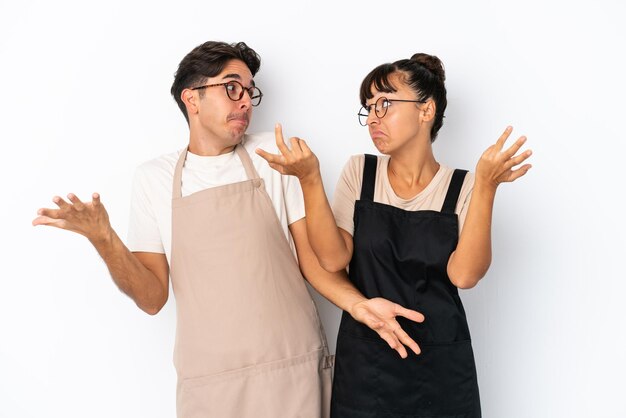 Restaurant gemengd ras obers geïsoleerd op een witte achtergrond die een onbelangrijk gebaar maken terwijl ze de schouders optillen