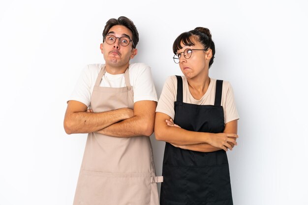 Restaurant gemengd ras obers geïsoleerd op een witte achtergrond twijfels gebaar maken terwijl het opheffen van de schouders