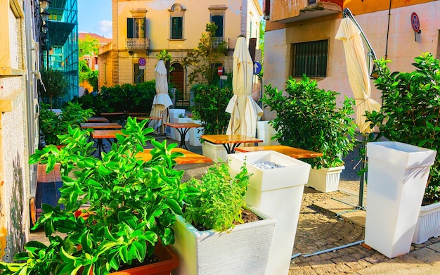 Restaurant in Corso Umberto I Street in de oude stad Olbia op het eiland Sardinië in Italië. Toeristen in cafés met tafels in de stad op Italiaanse Sardegna. Gemengde media.