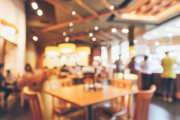 Restaurant interior with customer and wood table blur abstract background with bokeh light