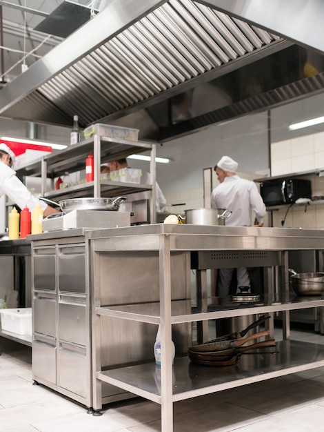 Foto interno della cucina del ristorante. area di lavoro di cuochi talentuosi e di successo. superfici di lavoro pulite e ordinate