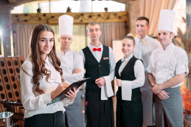 Restaurant manager and his staff in kitchen. interacting to head chef in commercial kitchen.