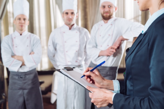 Restaurant manager and his staff in kitchen.