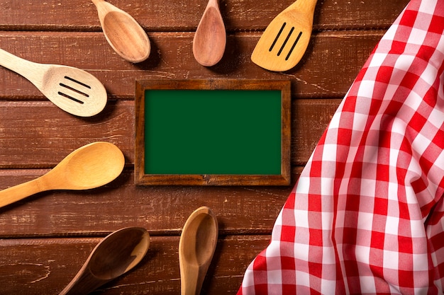 Restaurant menu. Bovenaanzicht van schoolbord menu tot op het rustieke houten bureau met lepels en rode servet.
