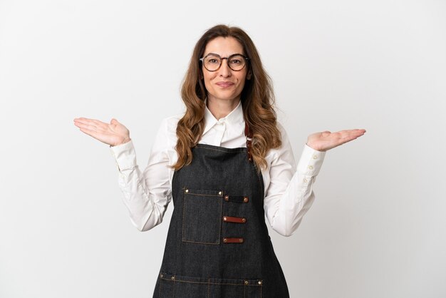 Restaurant middle aged waiter woman isolated on white background with shocked facial expression