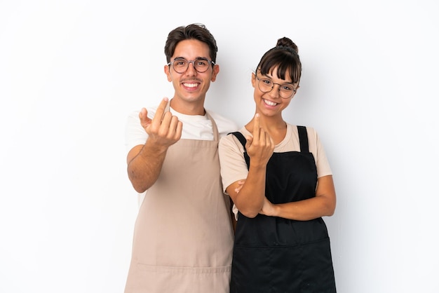 Restaurant mixed race waiters isolated on white background inviting to come with hand Happy that you came