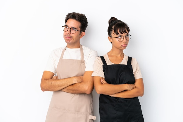 Restaurant mixed race waiters isolated on white background with confuse face expression while bites lip