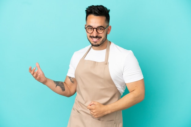 Foto restaurant ober blanke man geïsoleerd op blauwe achtergrond gitaar gebaar maken