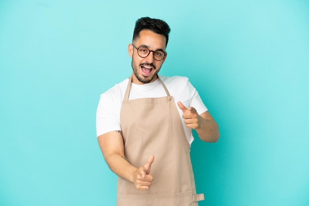 Restaurant ober blanke man geïsoleerd op blauwe achtergrond naar voren wijzend en glimlachend