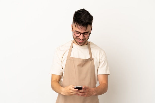 Restaurant ober blanke man geïsoleerd op een witte achtergrond die een bericht verzendt met de mobiel