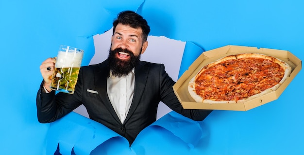 Foto restaurant of pizzeria glimlachende man met pizza en bier kijkend door papiergat italiaans eten pizza