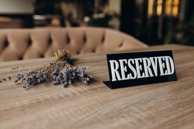 Restaurant reserved table sign standing on wooden table