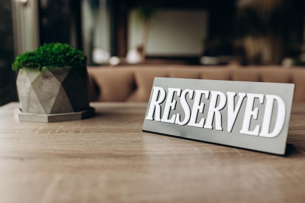 Restaurant reserved table sign standing on wooden table