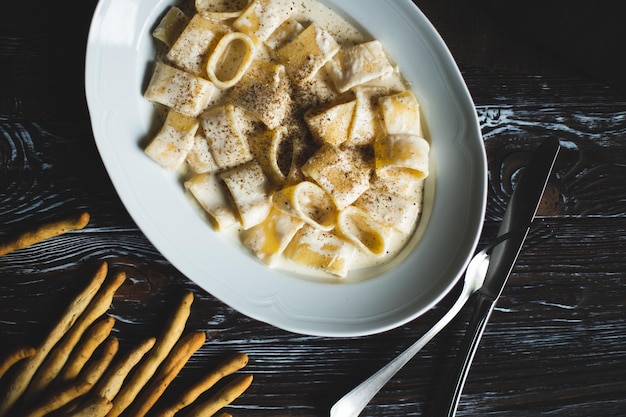 Restaurant serving pasta with parmesan and pepper. Food photography. Table setting.