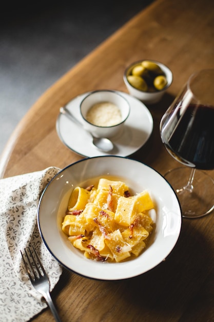 Restaurant serving pasta with parmesan and pepper. Food photography. Table setting.