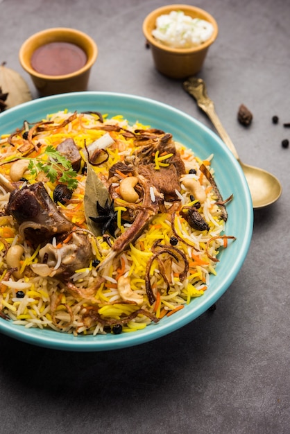 Gosht o biryani di montone in stile ristorante servito in una ciotola con raita e salan