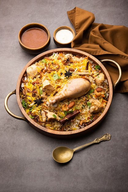 Ресторанный стиль Spicy Chicken Biryani подается с раитой и саланом, популярными индийскими или пакистанскими невегетарианскими блюдами.