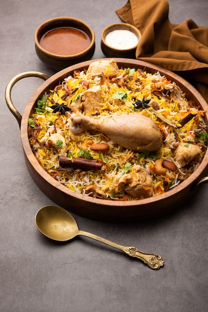 Ресторанный стиль Spicy Chicken Biryani подается с раитой и саланом, популярными индийскими или пакистанскими невегетарианскими блюдами.