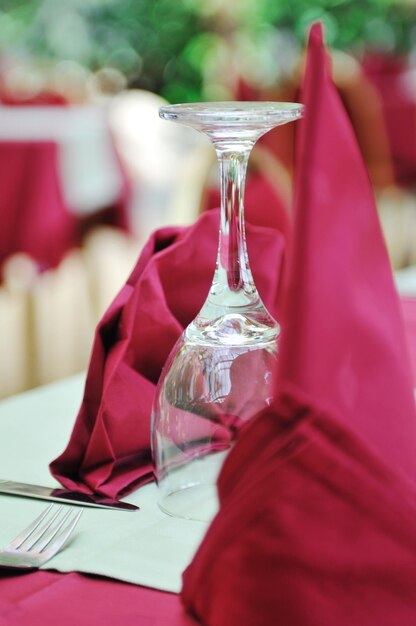 Restaurant table with empty wine glass and red table decoration
