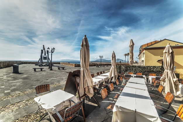 Restaurant tables and chairs in Alghero seafront Italy