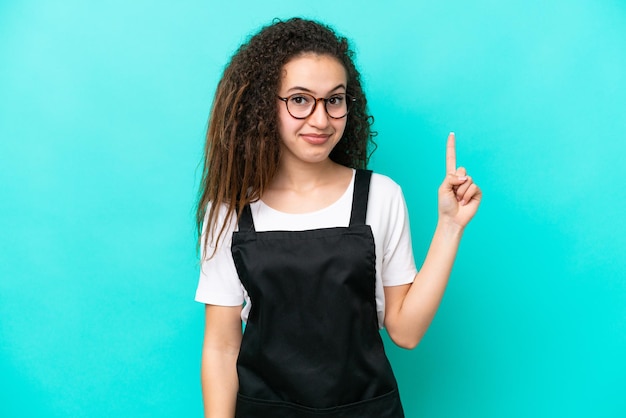 Restaurant waiter Arab woman isolated on blue background pointing with the index finger a great idea