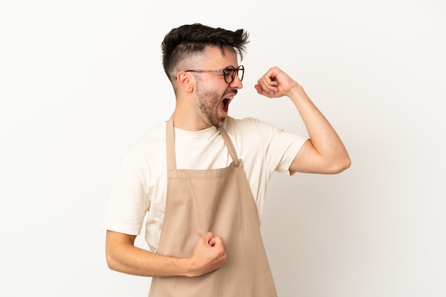 Restaurant waiter caucasian man isolated on white background celebrating a victory