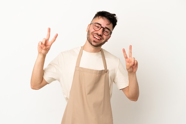 Restaurant waiter caucasian man isolated on white background showing victory sign with both hands
