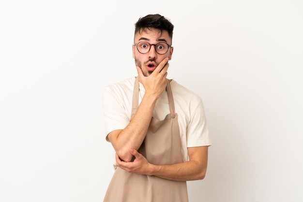 Restaurant waiter caucasian man isolated on white background surprised and shocked while looking right