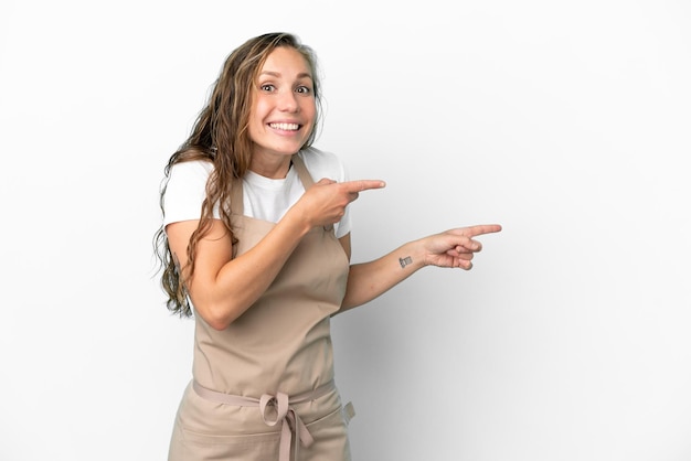 Restaurant waiter caucasian woman isolated on white background surprised and pointing side